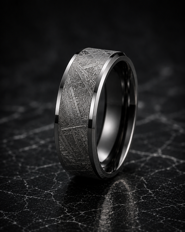 Silver ring with textured design on a dark marble surface