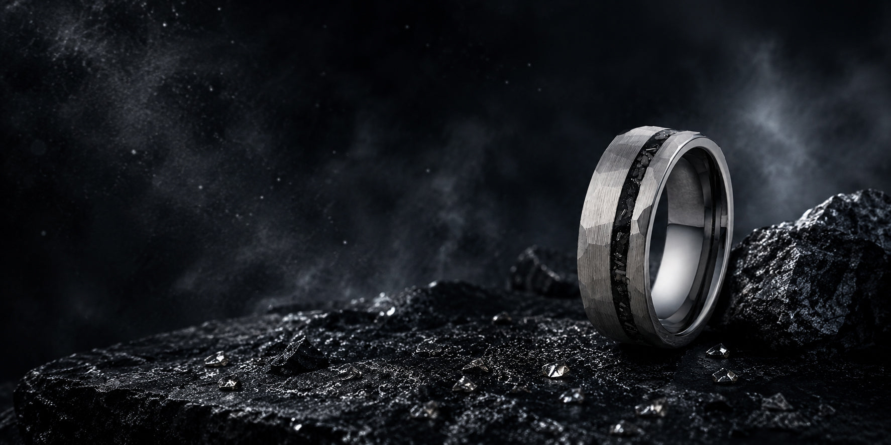 Silver meteorite tungsten wedding ring positioned on dark volcanic stone with atmospheric cinematic background and space-inspired masculine styling