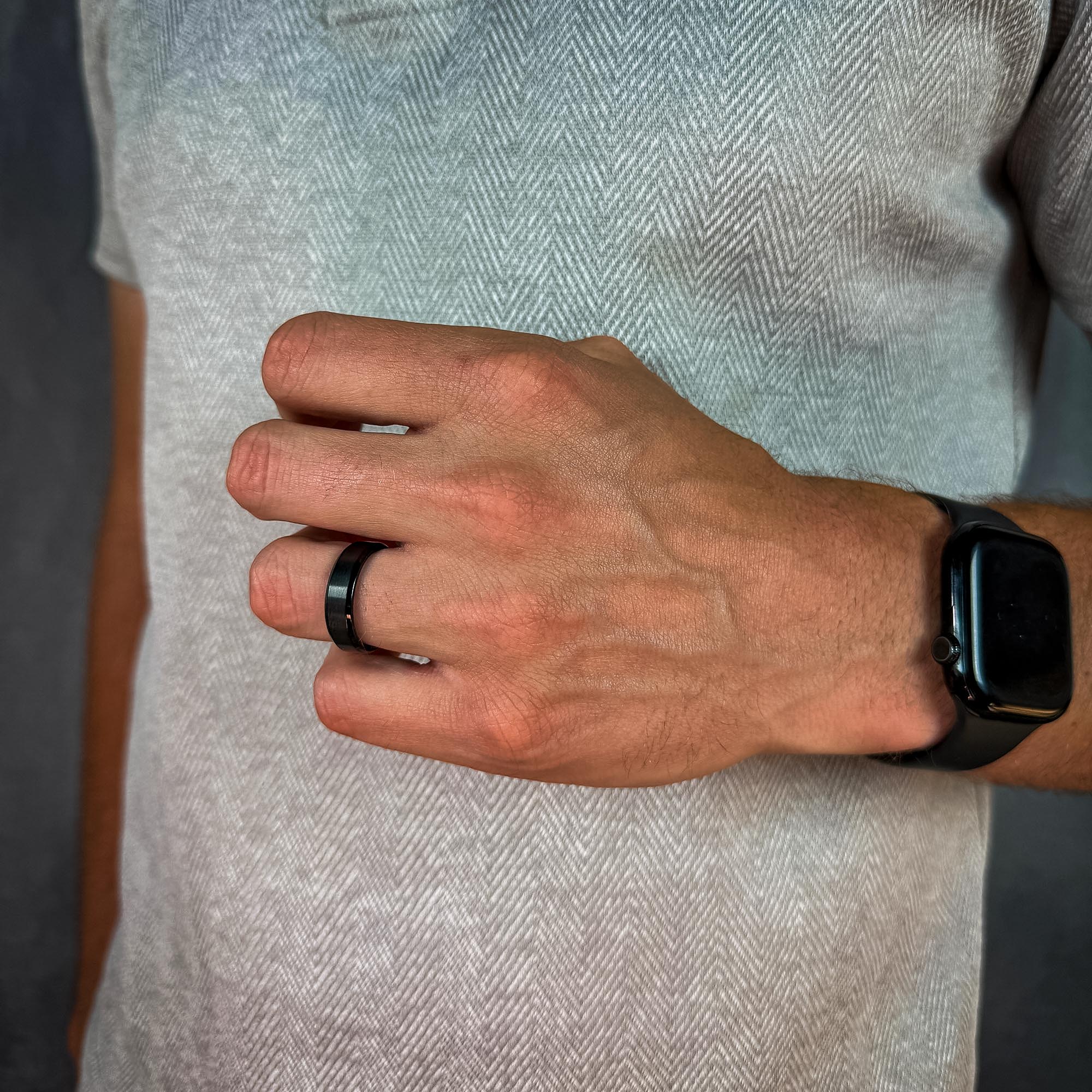 close up of a man wearing a black & blue titanium ring