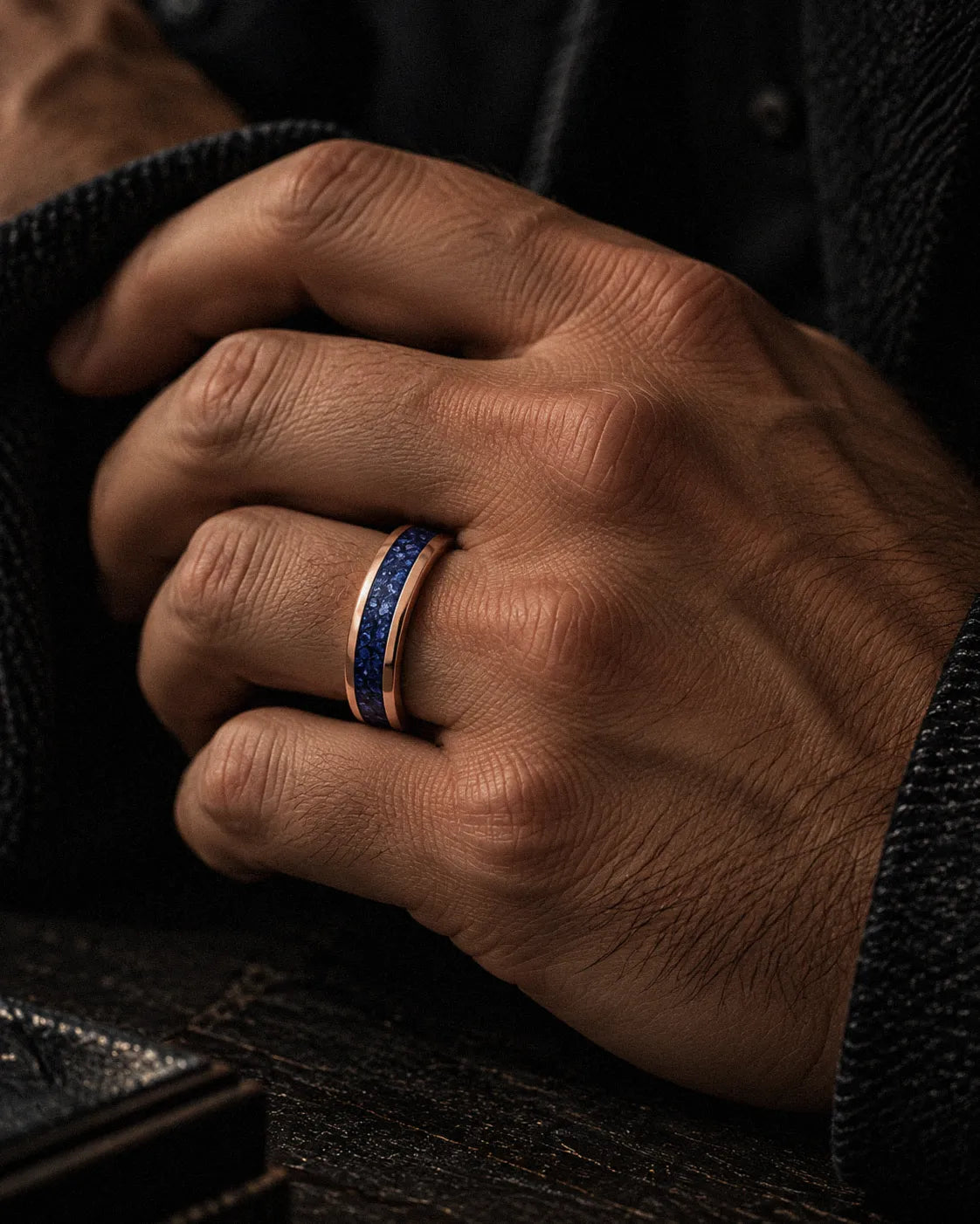 Man wearing a rose gold tungsten wedding ring with blue sapphire inlay