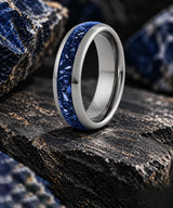 Silver sapphire gemstone wedding ring on dark textured stone