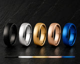 Men's wedding ring colour comparison featuring black, silver, gold, rose gold and blue tungsten wedding bands displayed on dark slate with a colour spectrum guide below.