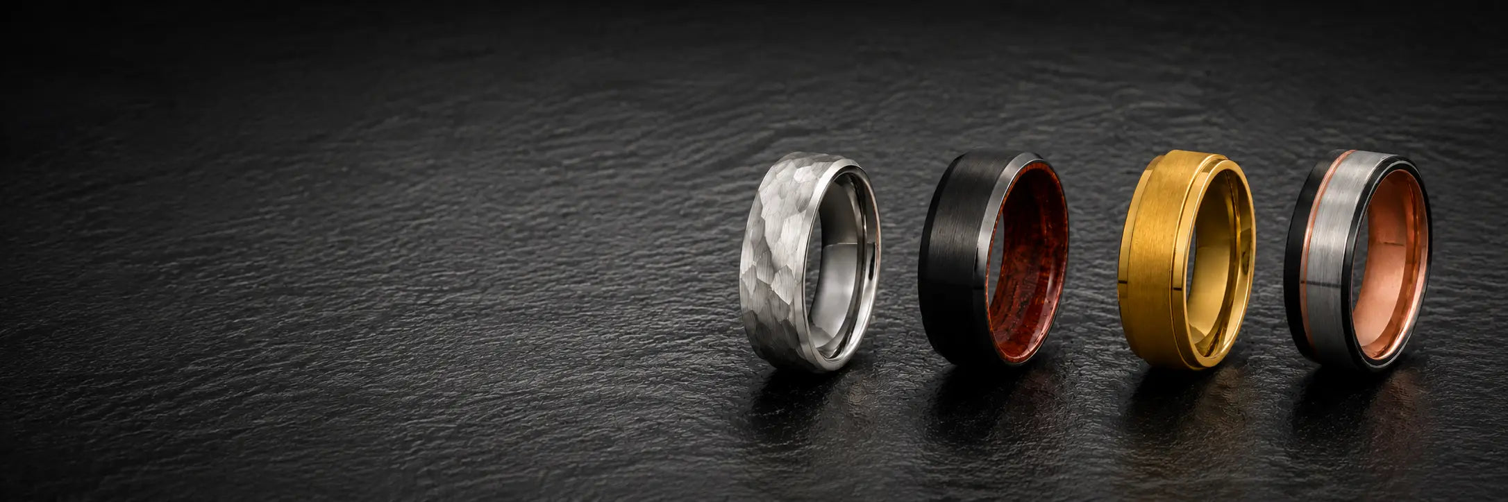 Men's wedding ring style collection featuring hammered, whiskey barrel, gemstone, classic and modern wedding bands on a dark luxury background.