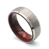 Angled view of a silver beveled tungsten whiskey barrel wedding ring with a real maple wood interior.