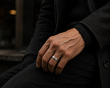 Man wearing a silver brushed wedding ring with dark luxury styling and cinematic urban background