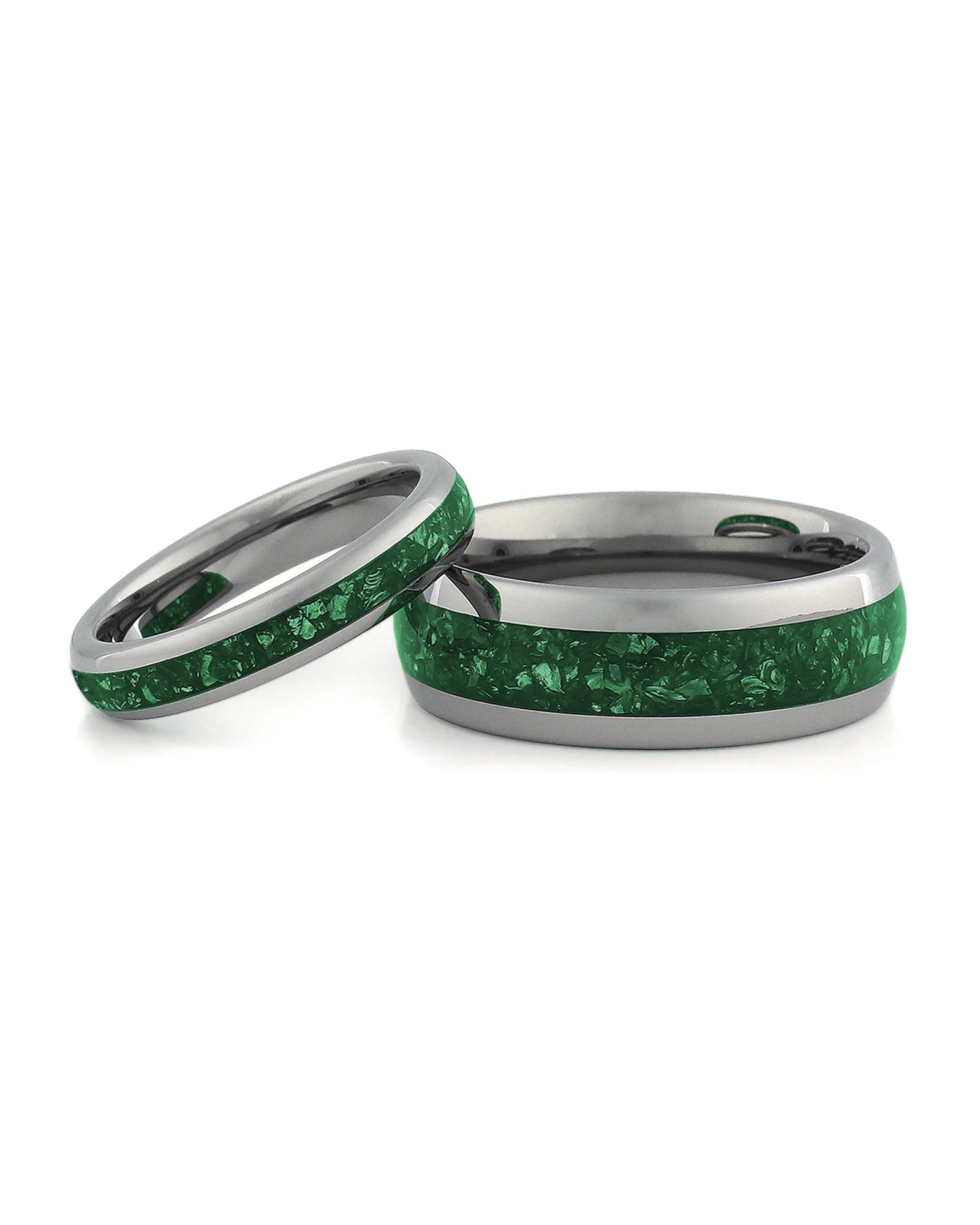Matching silver wedding bands with green emerald stone inlays