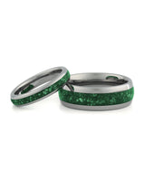 Matching silver wedding bands with green emerald stone inlays