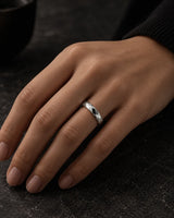 Woman wearing a silver 4mm faceted tungsten wedding ring on her ring finger