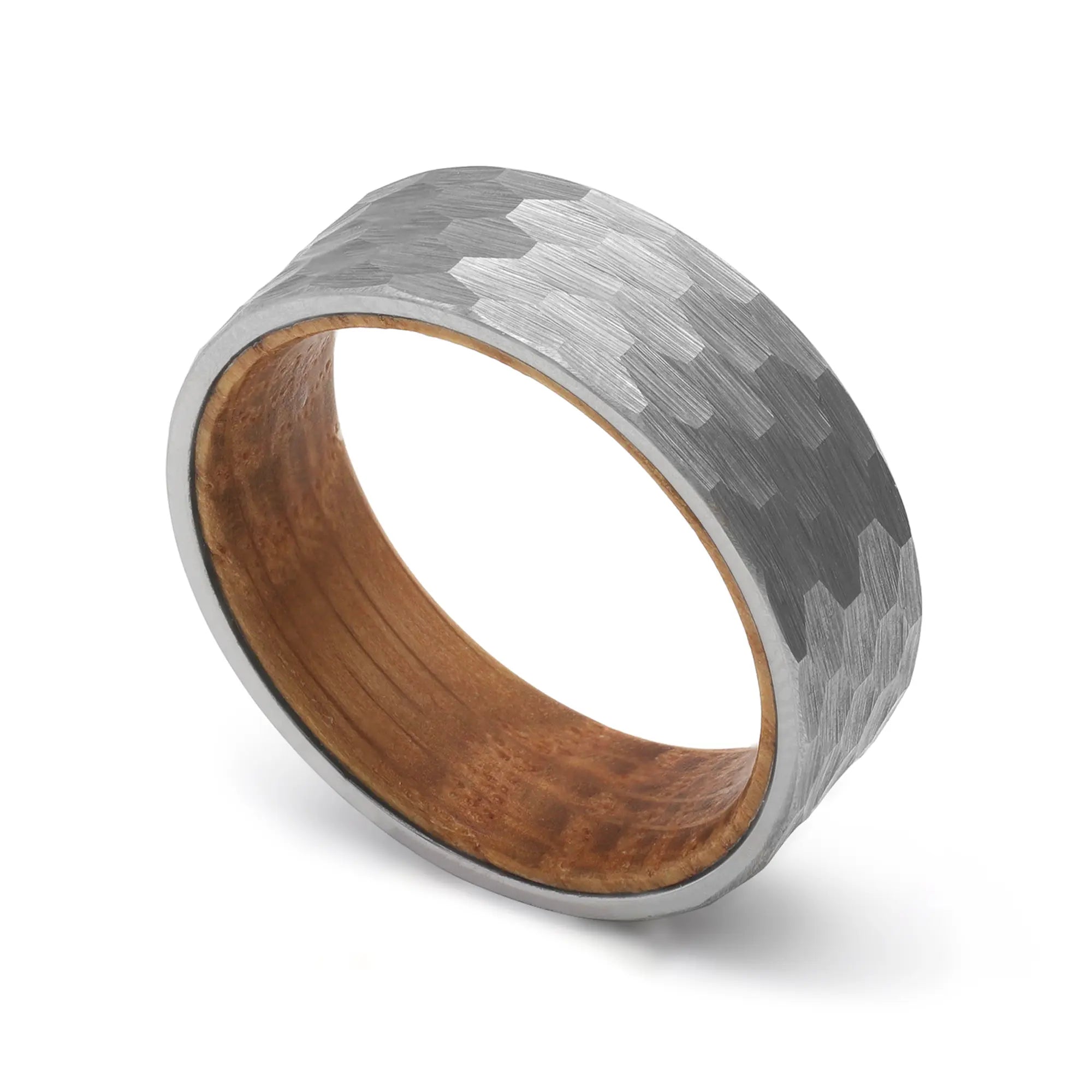 Angled view of a silver hammered tungsten whiskey barrel wedding ring with a real oak wood interior.