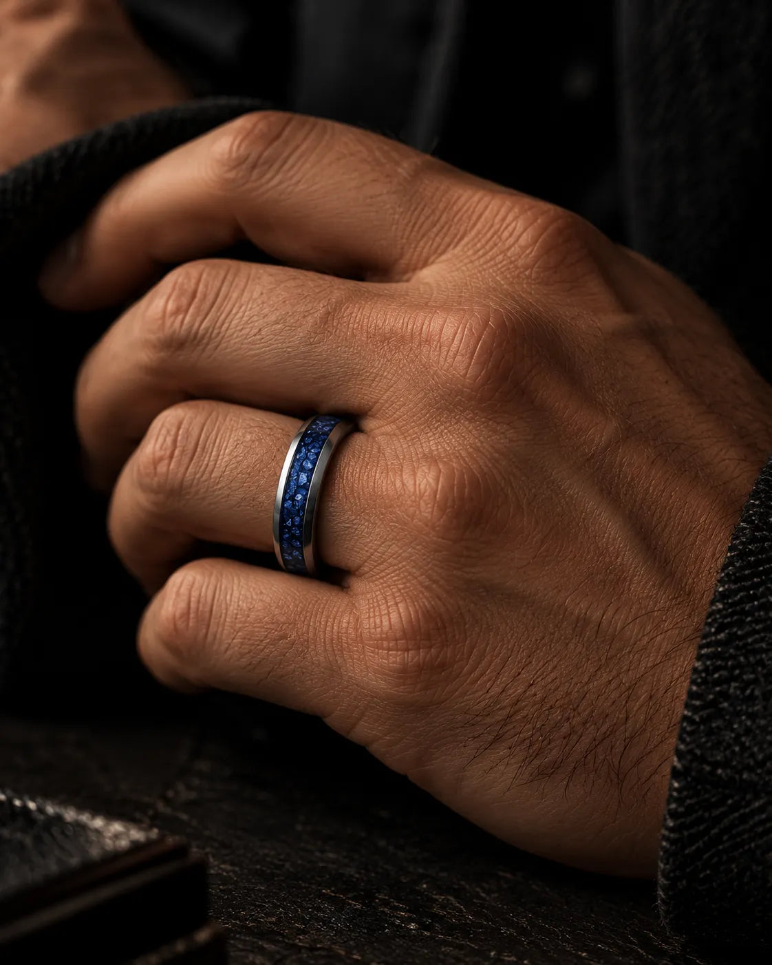 Man wearing a silver tungsten wedding ring with blue sapphire inlay