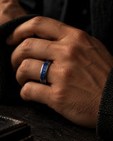 Man wearing a silver tungsten wedding ring with blue sapphire inlay