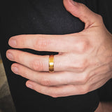 close up of a man wearing a gold titanium wedding band