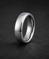 Traditional silver tungsten wedding ring with a plain polished finish on a dark stone background.