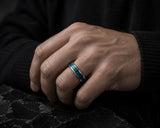 Man wearing silver tungsten wedding ring with turquoise gemstone inlay in luxury lifestyle setting