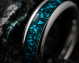 Macro close-up of turquoise gemstone inlay wedding ring showing detailed stone texture and polished tungsten edges