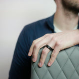 close up of a man wearing a black tungsten wedding ring with a whiskey barrel wood sleeve