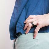 man with hand on hip wearing a black tungsten wedding ring