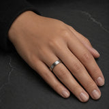 Woman wearing a 4mm brushed silver tungsten wedding ring with polished black inner band