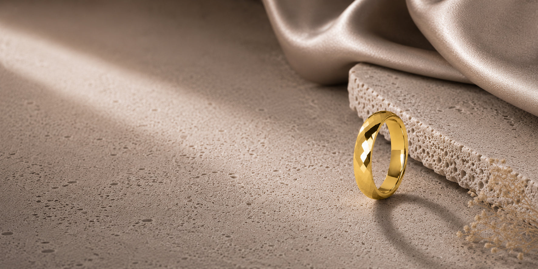 Women’s faceted gold wedding ring luxury desktop hero banner with soft neutral textures and elegant feminine styling